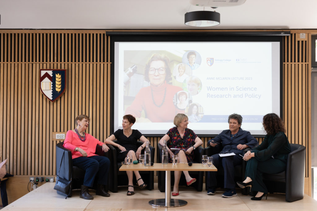 Sarah Franklin, Emily Jackson, Susan Michie, Dorothy Bishop and Helena Rodriguez Caro seated on the stage under an image of Anne McLaren on the large screen