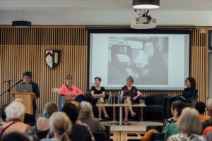 Emily Jackson, Susan Michie, Dorothy Bishop and Helena Rodriguez Caro on the stage watching Sarah Franklin speaking at the lectern.