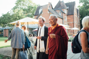 Ringu Tulku Rinpoche and Jonathan Michie walking together outside the Kellogg Hub