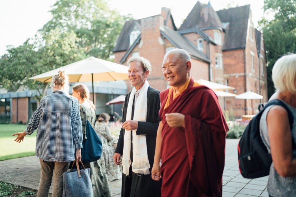 Ringu Tulku Rinpoche and Jonathan Michie walking together outside the Kellogg Hub