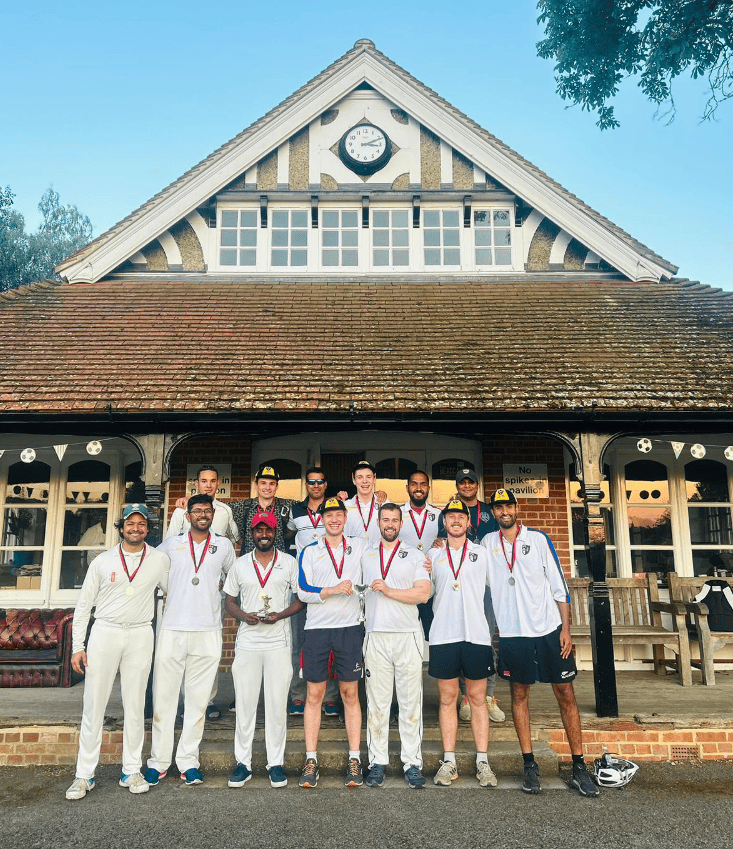 Kellogg Cricket team holding the Fortress T20 Runners-up cup outside the New College pavilion