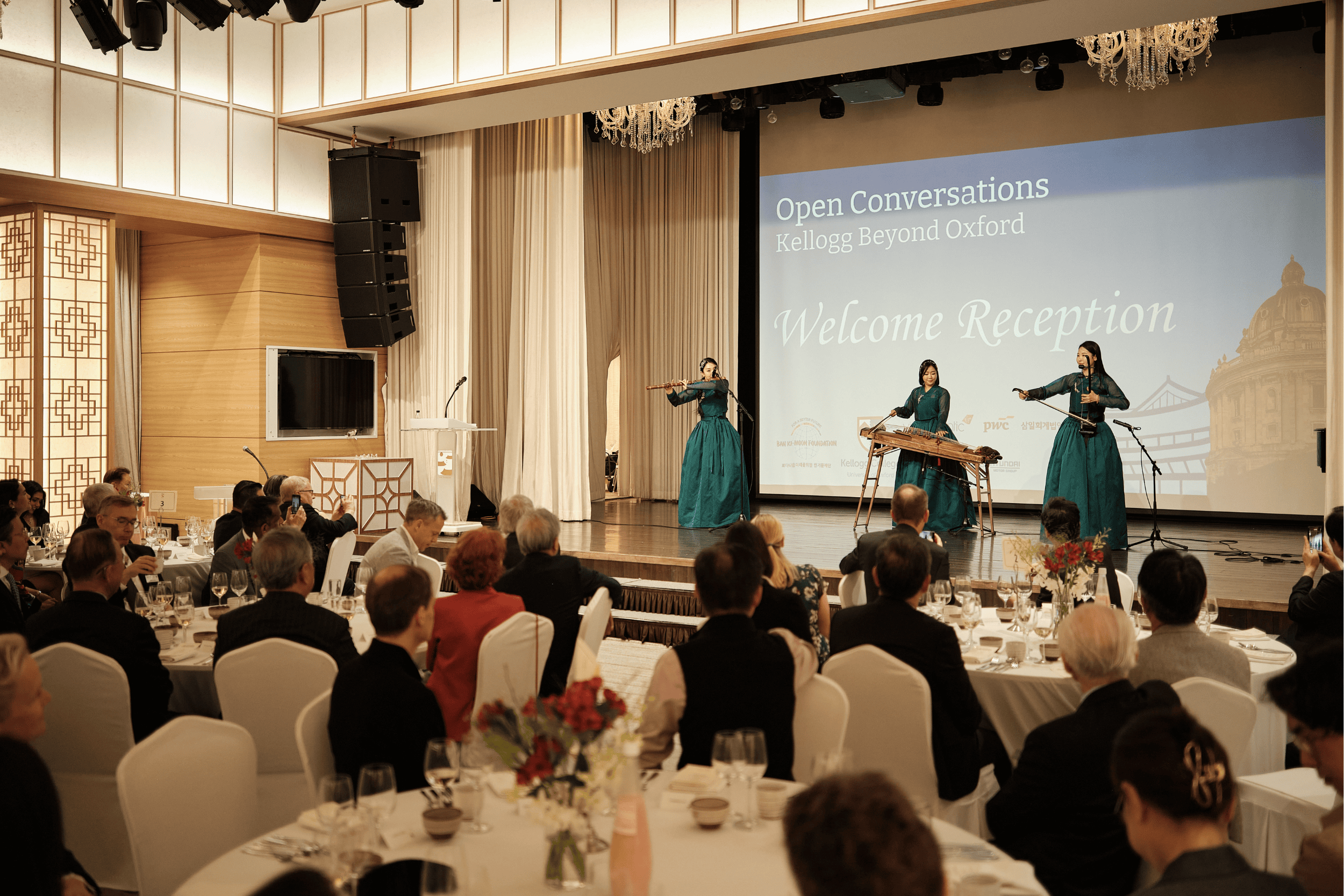 Guests seated at tables watch a traditional Korean music performance on stage during the Open Conversations welcome reception in Seoul.
