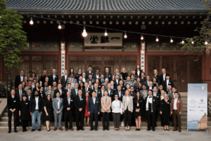 Group photograph of Open Conversations attendees standing on the steps of a traditional Korean building in Seoul, including alumni, academics, and global leaders gathered for the Kellogg College event.