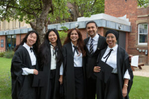 Group of students smiling at the camera on the college lawn