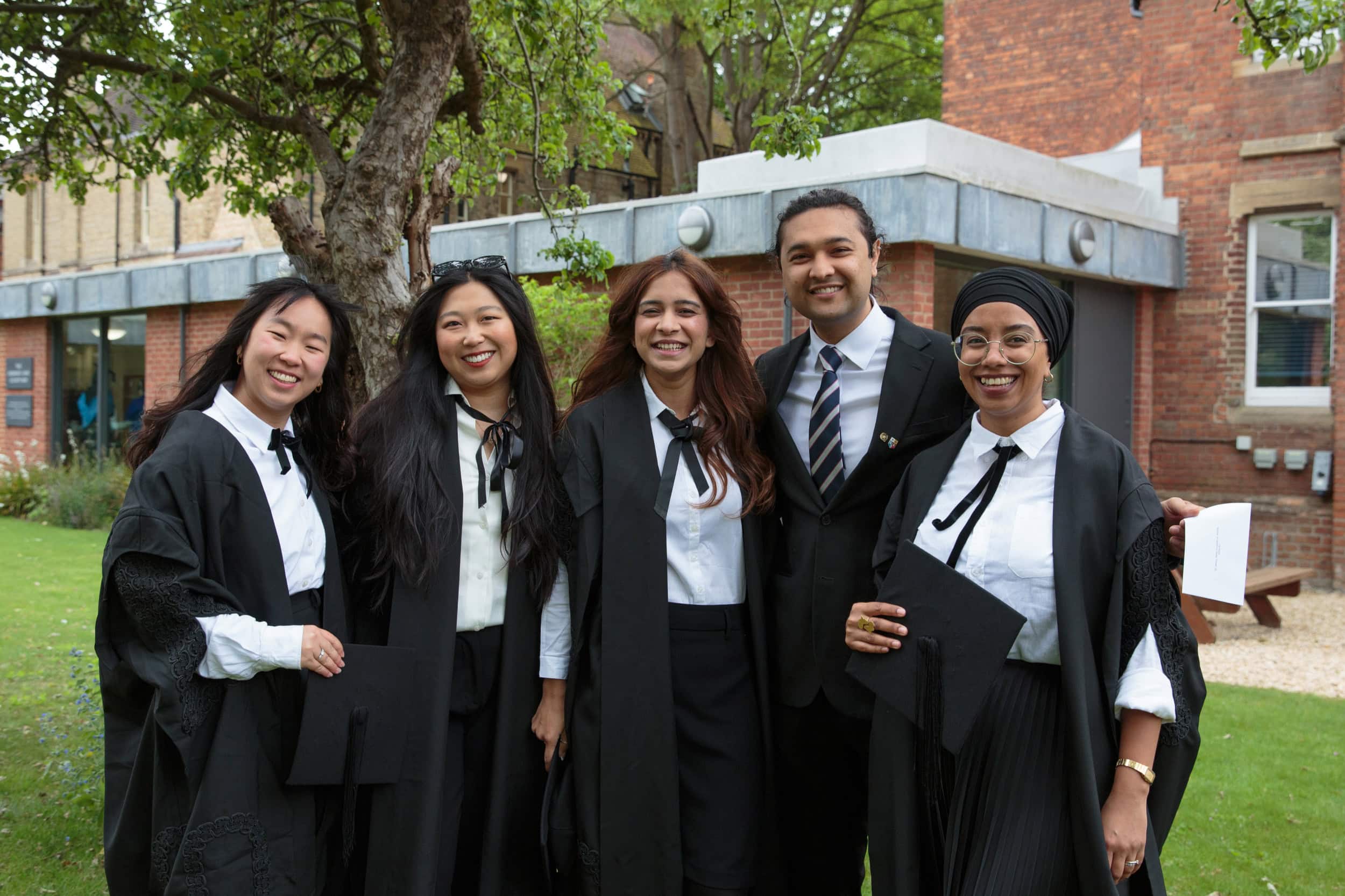 Group of students smiling at the camera on the college lawn